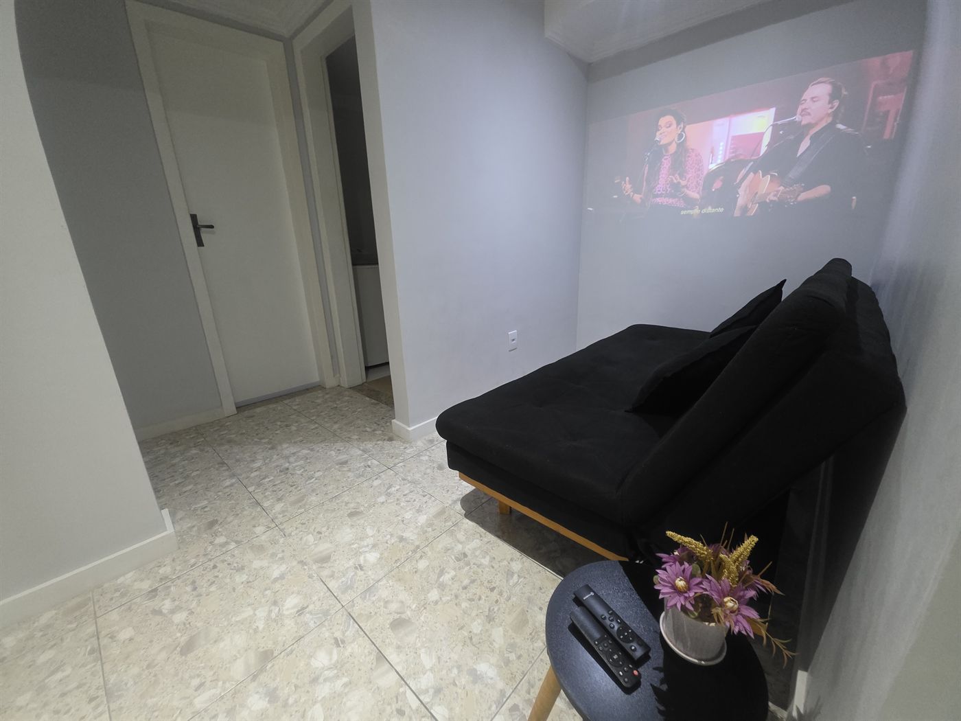 Suíte Rooftop — sala com projetor e sofá-cama